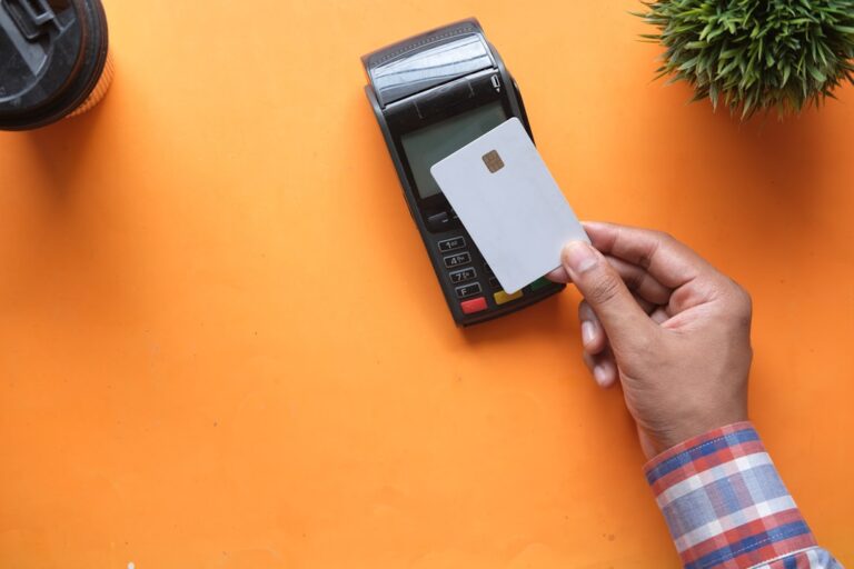 A shop owner updates payment terminal security settings at a small retail counter.