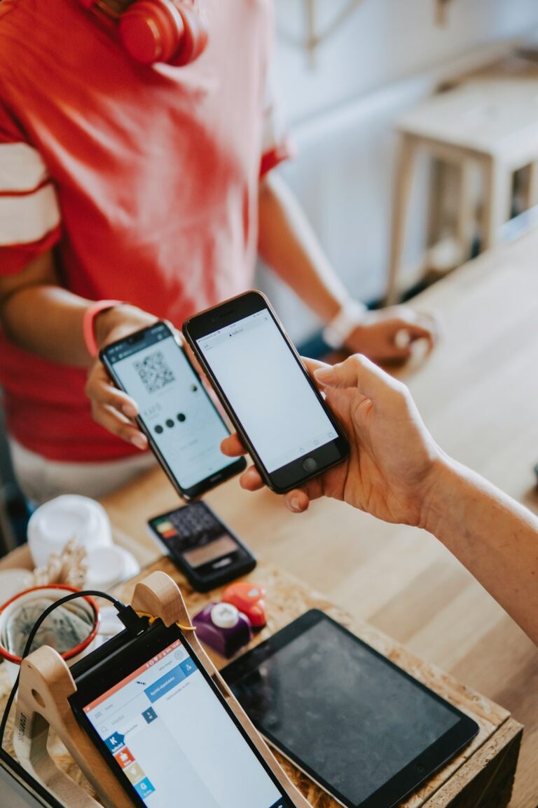 Person holding a card above a payment terminal at a checkout counter while making a purchase.